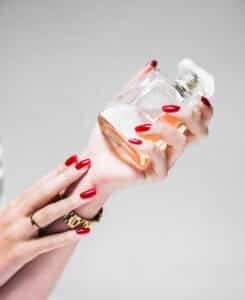 person holding clear glass bottle